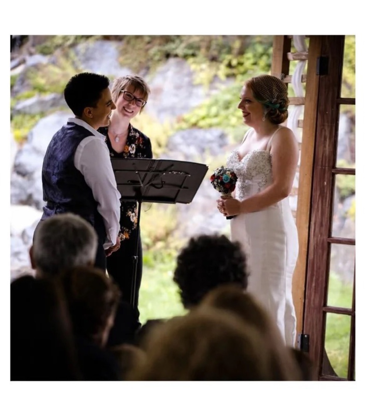 Rev. Tracy officiating a wedding ceremony for a smiling couple