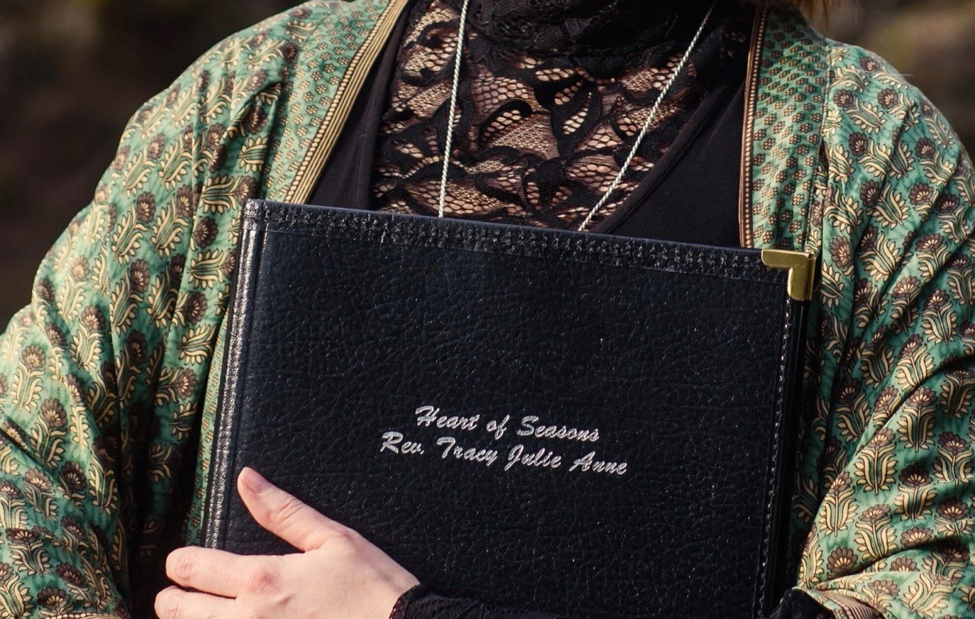 Rev. Tracy holding her embossed Heart of Seasons ceremony book